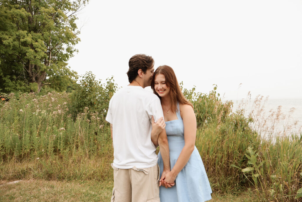 man and woman standing close, man kissing woman's head